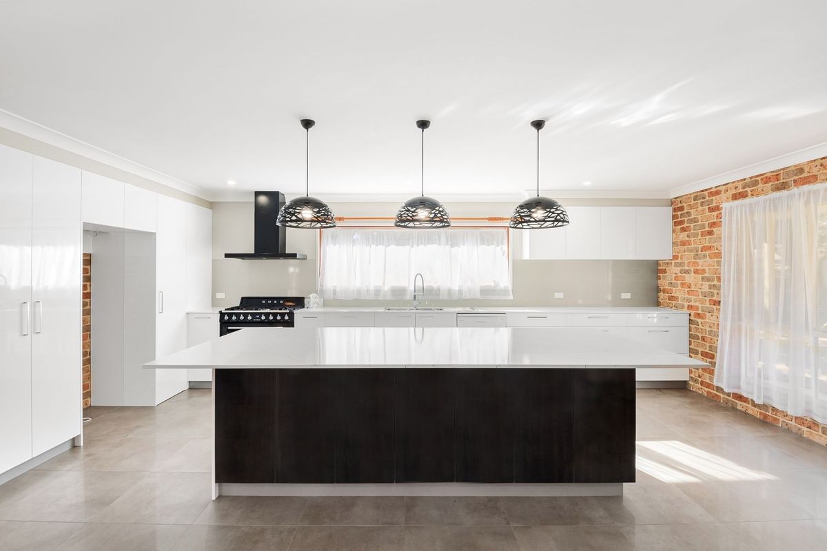 Cocina reformada con muebles claros y encimera de piedra